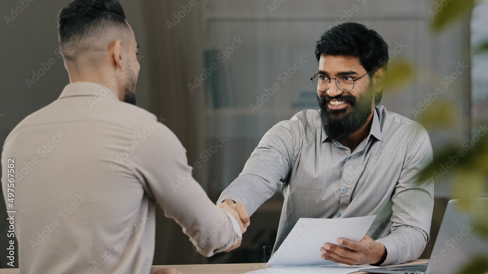 Fototapeta premium Male arab businessman man financial consultant analyst lawyer consult hispanic client customer explain project document contract at business meeting make bank loan insurance shaking hands agreement
