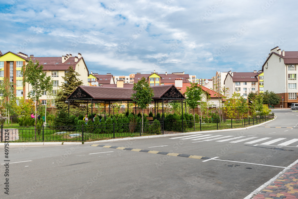pedestrian crossing and road against the background of a residential complex with a park