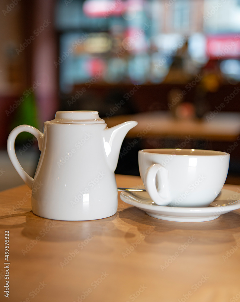 Fototapeta premium White tea pot and tea cup in a saucer
