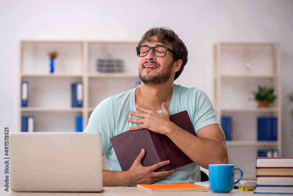 Young male student preparing for exams in the classroom