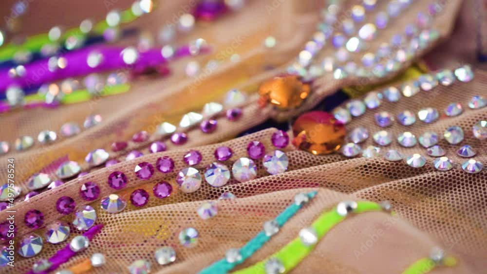 Close up of rhinestones and colorful fabric on figure skating dress.