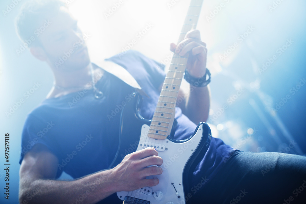 Making music. Cropped view of a rock star playing the guitar during a  gig-This concert