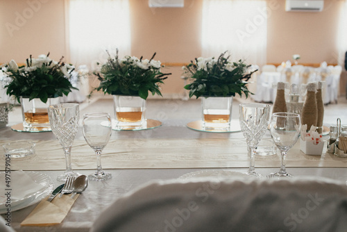 Table decoration for a special occasion - white plates and green plants. Eco/nature friendly decoration. 