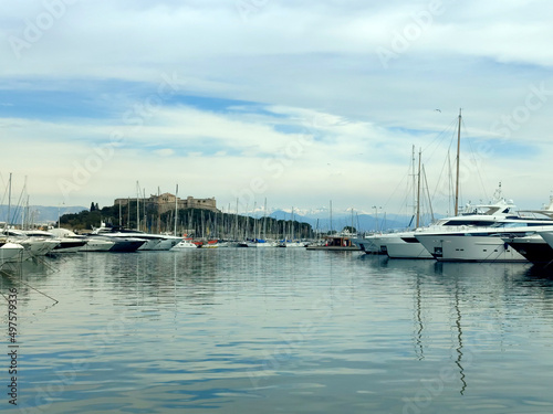 Port Vauban et fort carré à Antibes sur la Côte d'Azur avec un parterre de yachts et de voiliers et les sommets enneigés du Mercantour en arrière plan