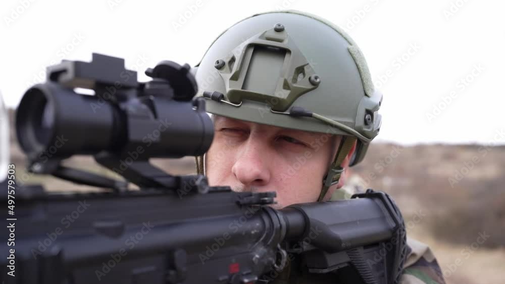 one man front view portrait of soldier in camouflage uniform armed with rifle ready to go on a mission in war zone standing outdoor in nature aiming dogs of war mercenaries or volunteer one man front view portrait of soldier in camouflage uniform armed with rifle ready to go on a mission in war zone standing outdoor in nature aiming dogs of war mercenaries or volunteer