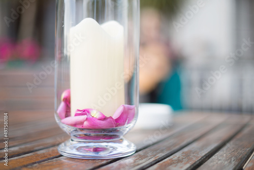 candle and rose petals in glass jar 