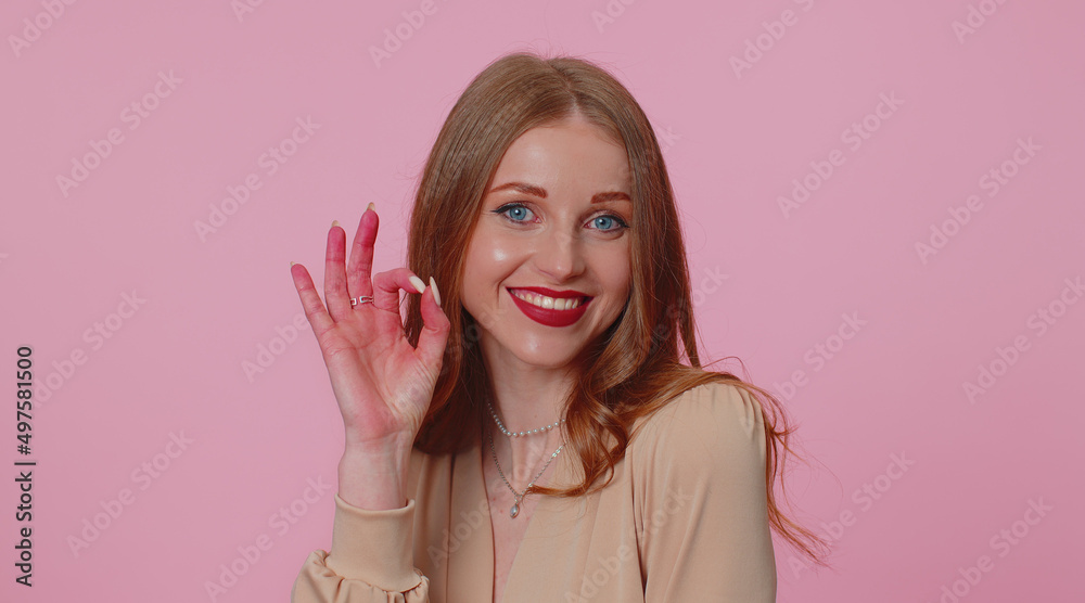 Happy positive businesswoman girl in beige blouse looking approvingly at camera showing ok gesture, like sign positive something good. Young adult woman isolated alone on pink studio background Happy positive businesswoman girl in beige blouse looking approvingly at camera showing ok gesture, like sign positive something good. Young adult woman isolated alone on pink studio background