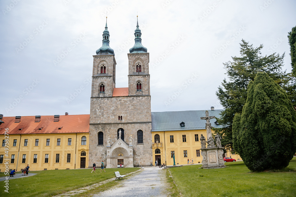 Tepla, Czech Republic, 7 August 2021: Premonstratensian Abbey and monastery, Romanesque church of the Annunciation with towers, gothic arched portal with stone carved statues of saints at summer day