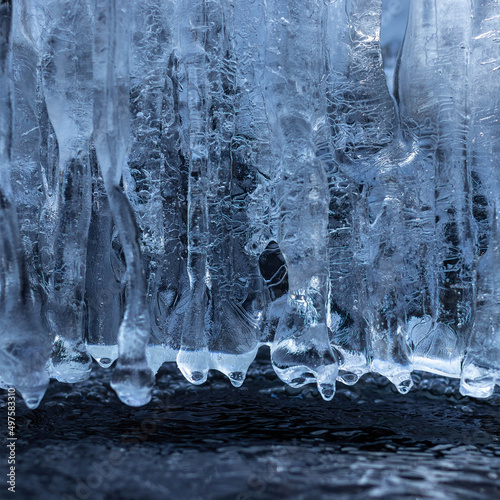 Icicles on the rocks. Ice texture details. Frozen wallpaper  