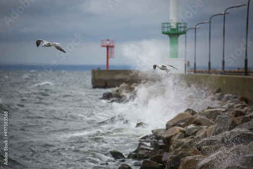 Piękne morze Bałtyckie, duże fale rozbijające się o brzeg skał, falochrony i mola. Spacer brzegiem plaży latające mewy, statki pasazerskie. © Artur Wojtczak 