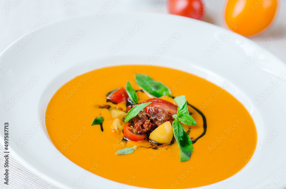 Delicious creamy tomato soup with herbs. Summer light yellow tomato soup. Delicious creamy tomato soup with herbs. Summer light yellow tomato soup.