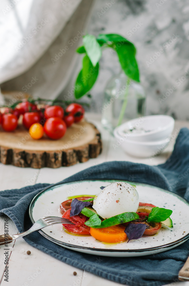 Buffalo burrata cheese served with fresh raw tomatoes and basil leaves