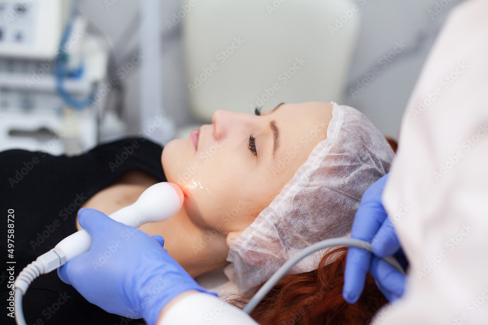 Woman receiving ultrasonic facial massage on ultrasound face machine.
