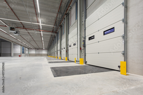 Fototapet Interior of a new empty warehouse with loading docks ready to be used
