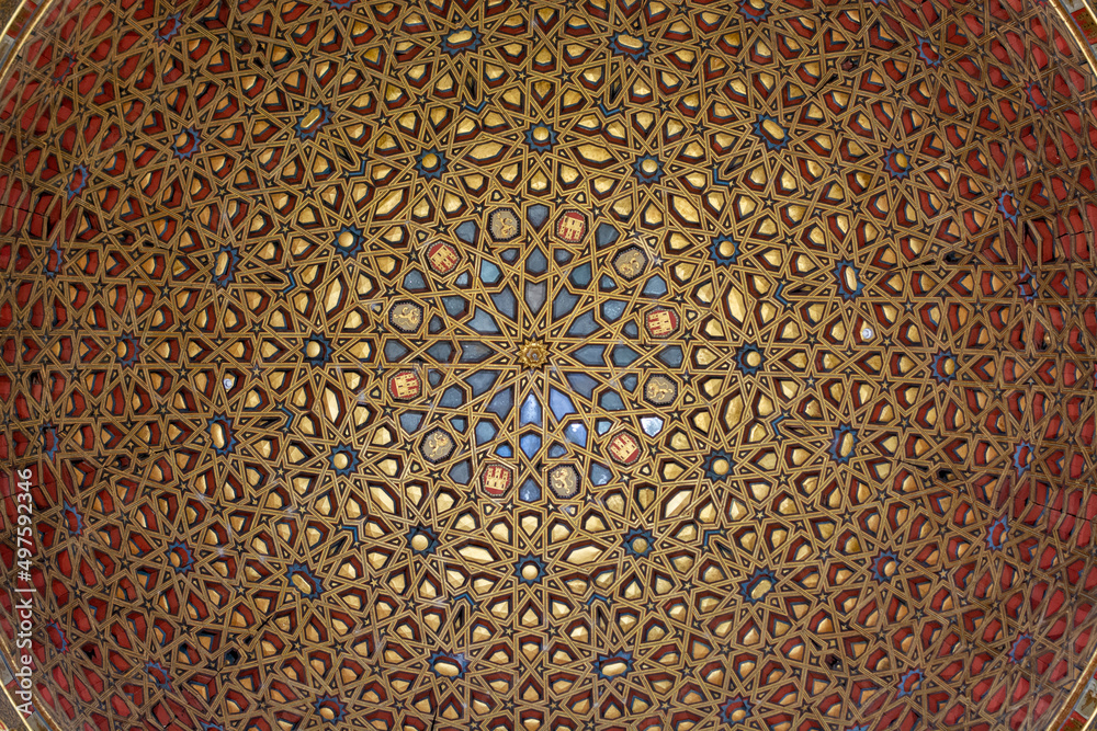 Naklejka premium View on Mudejar style architectural details of ceiling in royal palace.. Old historical Andalusian town Seville, Spain.