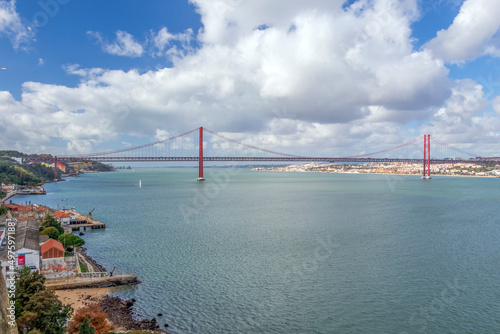 The 25 de Abril Bridge, 25th of April Bridge, a red suspension bridge over the Tagus river, Lisbon, Portugal
