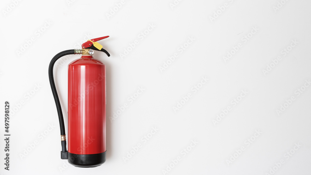 Red fire extinguisher hanging on white wall