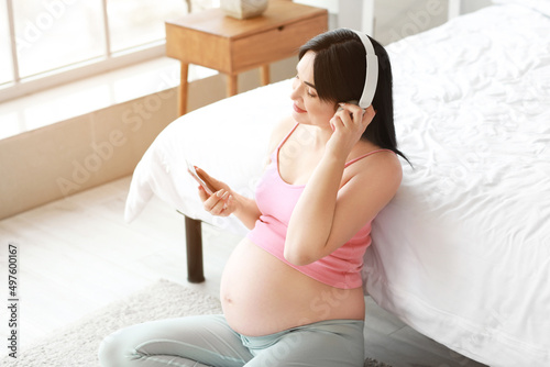 Young pregnant woman listen...