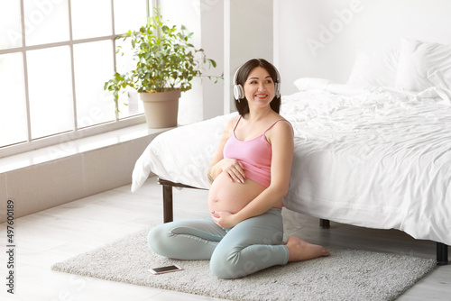 Young pregnant woman listen...