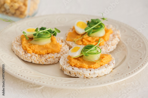Plate with crispbreads and tasty hummus on white background