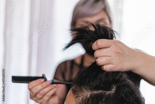 Unknown woman giving her client a haircut 