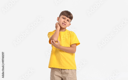 Little boy scratching himself on white background