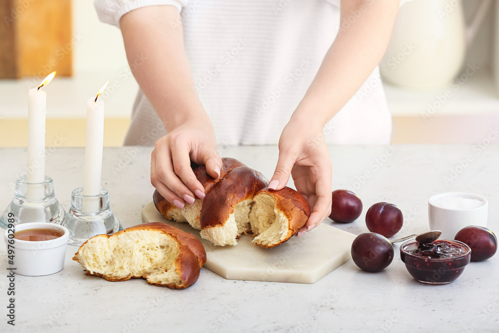 Woman with fresh challah bread on table Woman with fresh challah bread on table