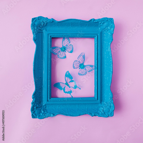 A retro old fashionned pastel blue frame with blue butterflies against pastel pink background. Romantic spring summer design for card, web banner or editorial photo