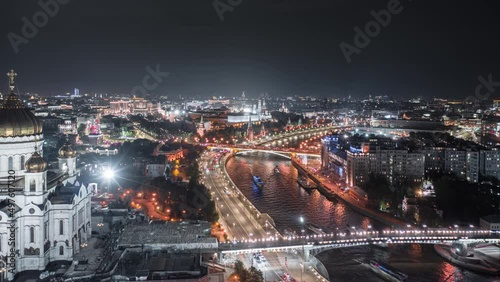 Beautiful aerial view to Moscow city center at night. Camera passing closely near the Cathedral of Christ the Savior and moving above the Moskva River towards the Kremlin in motion timelapse.