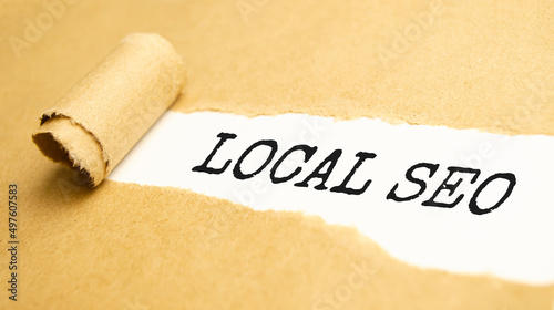 The text LOCAL SEO appearing behind torn yellow paper