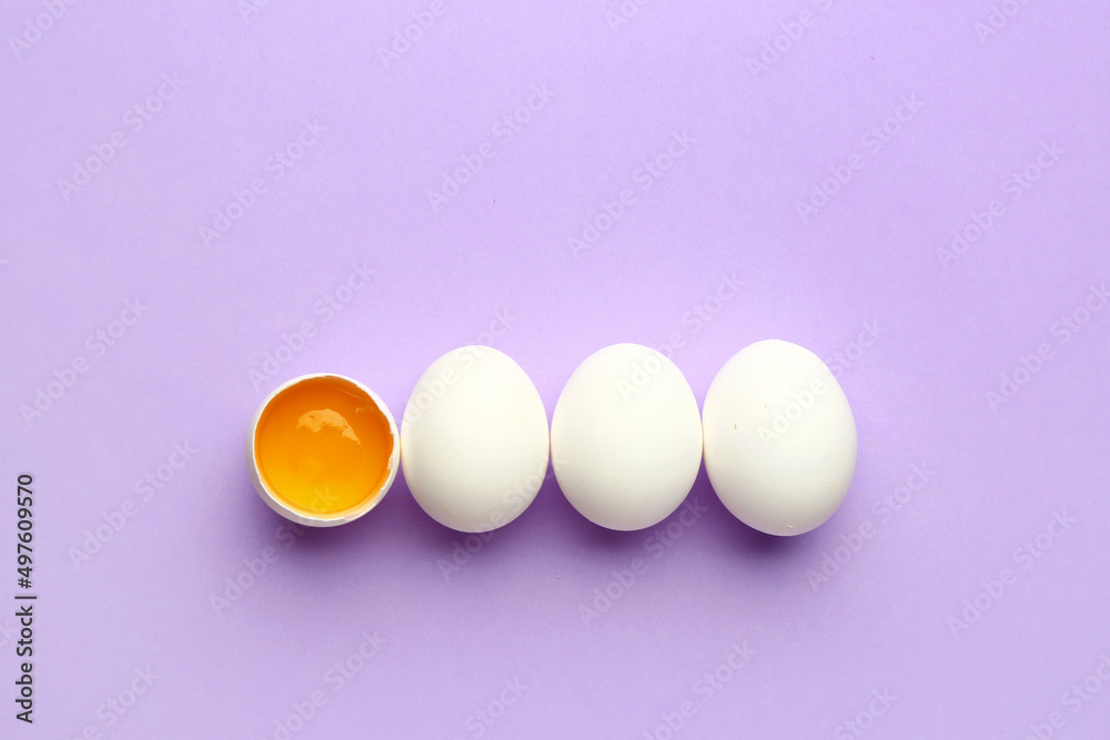 Cracked and whole chicken eggs on purple background. Concept of uniqueness