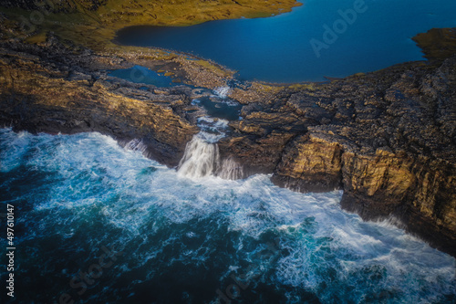 Panoramic view from flying drone of Bosdalafossur waterfall. Amazing autumn scene of Sorvagsvatn lake, Vagar, Faroe Islands, Denmark, Europe. Beauty of nature concept background. November 2021