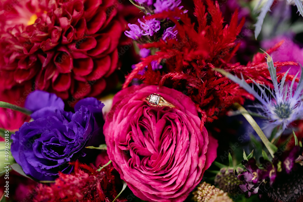 Diamond Ring Sits in Flowers of Colorful Bridal Bouquet