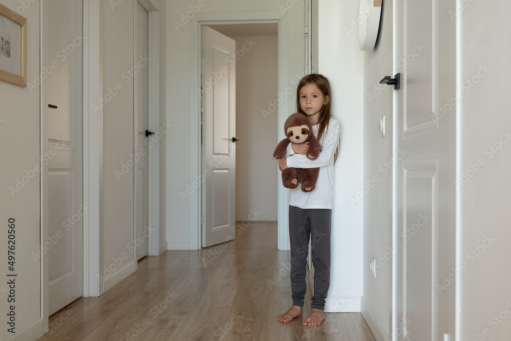 Lonely child with toy in corridor Lonely child with toy in corridor