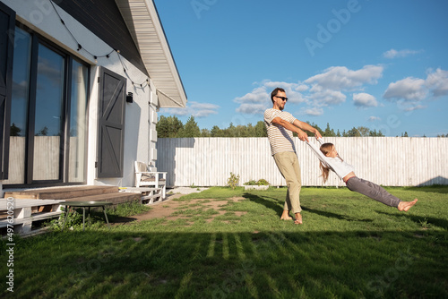 Father playing with daughter in backyard photo