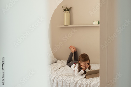 Girl watching cartoon on soft bed
