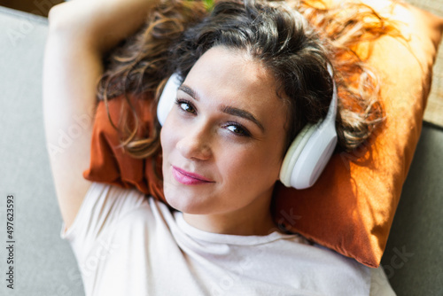 Woman looking at camera and listening to a music photo