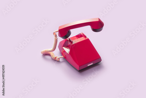 Red vintage telephone with handset off hook photo