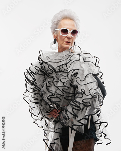 Senior lady in extravagant outfit and white sunglasses