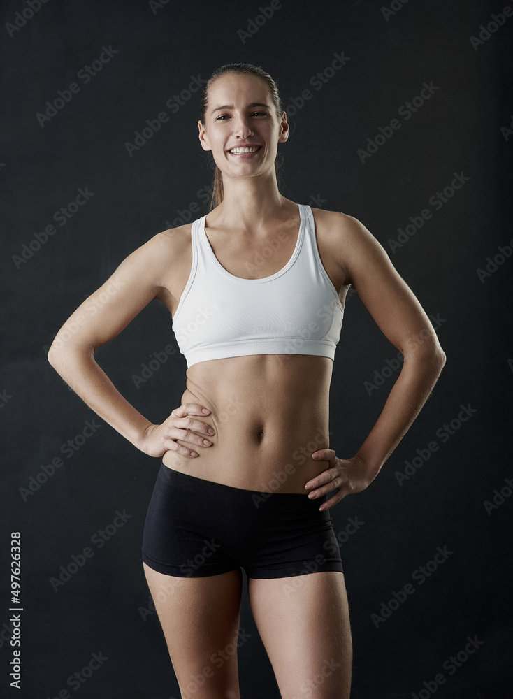 I work hard to look this good. Studio portrait of a sporty young woman standing against a dark background. I work hard to look this good. Studio portrait of a sporty young woman standing against a dark background.