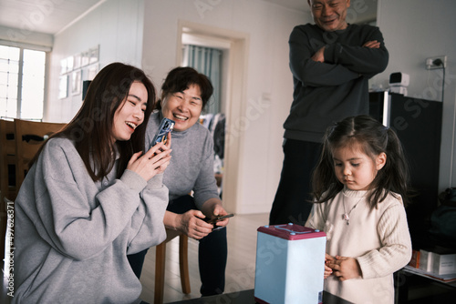 Little Multiracial Asian Girl Puts Chinese Yuan In Her Toy Safe.