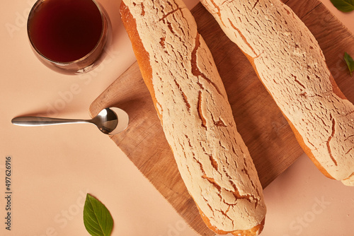 Traditional breakfast, pasta bread with pot coffee. Handmade sweet bread. Food. Sliced bread on wooden board on veige and pink color background. Local bakery. photo