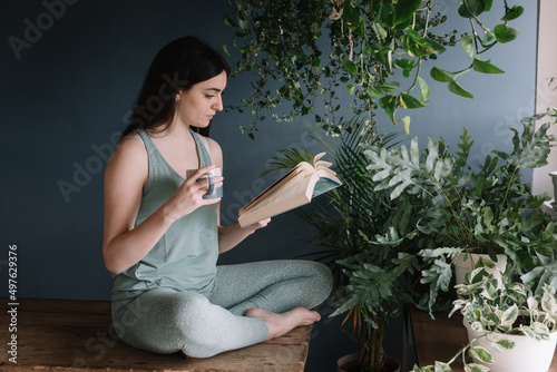 Young Woman Drinking Herb Tea In Studio On Wooden Table photo