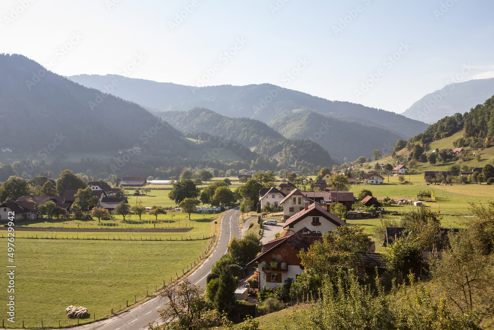 Aerial panorama of Ljubno ob Savinji, a typical central europea village of Slovenia, with individual houses, farmhouses, buildings, fields and julian alps mountains in a rural agricultural environment