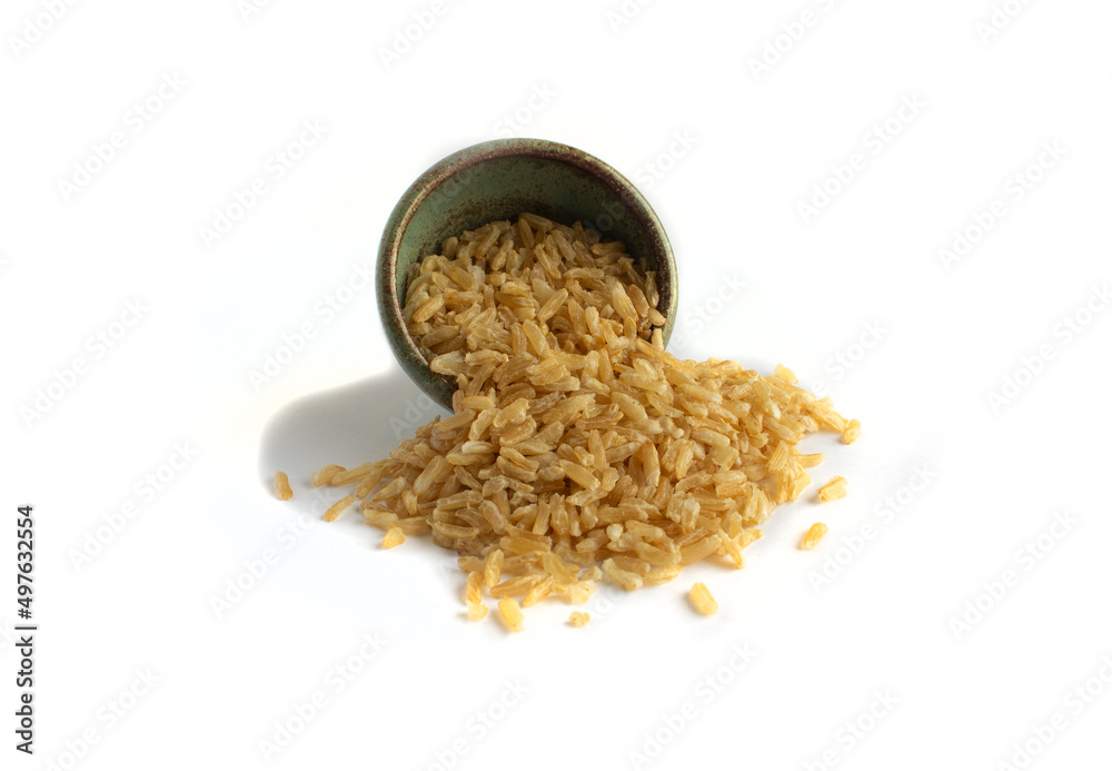 Instant Brown Rice Spills from Green Pottery Bowl Isolated on White Instant Brown Rice Spills from Green Pottery Bowl Isolated on White