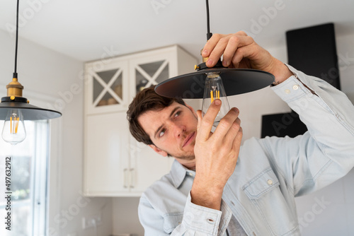 Portrait of man replacing light bulb at home photo