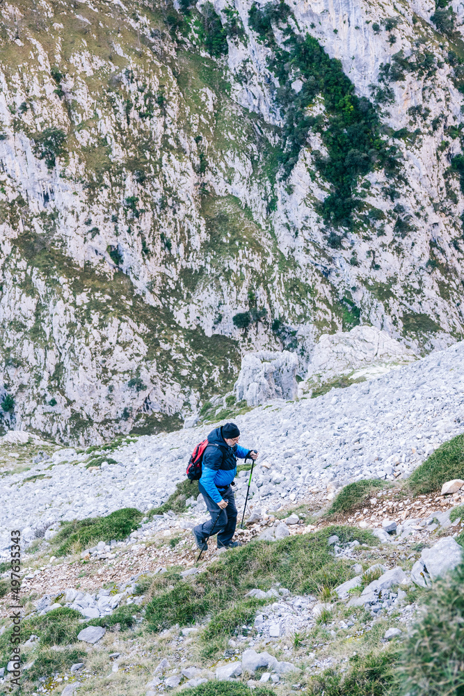 Hiker with backpack exploring mountain range Hiker with backpack exploring mountain range