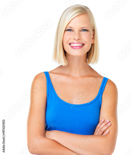 Cute confidence. Portrait of a young woman smiling and throwing her hair back with her arms folded.