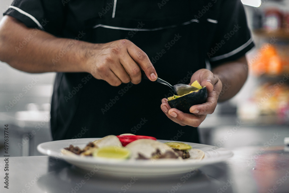 Anonymous chef plating tacos with avocado Anonymous chef plating tacos with avocado