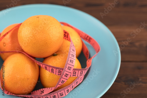 Oranges and a soft ruler on a plate